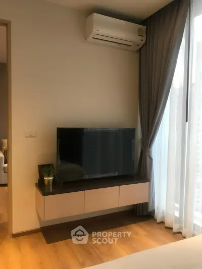 Modern living room with wall-mounted TV and air conditioning in a stylish apartment.
