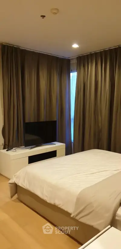 Cozy bedroom with modern decor and large windows for natural light.