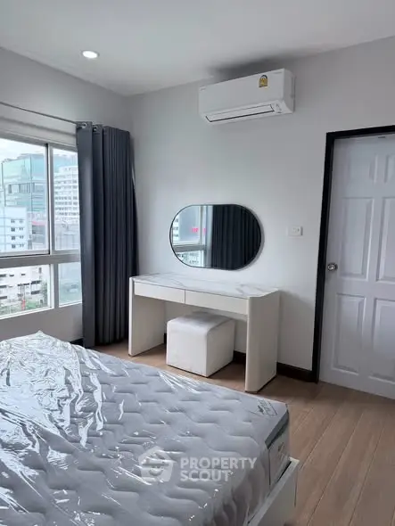 Modern bedroom with large window and air conditioning in urban apartment