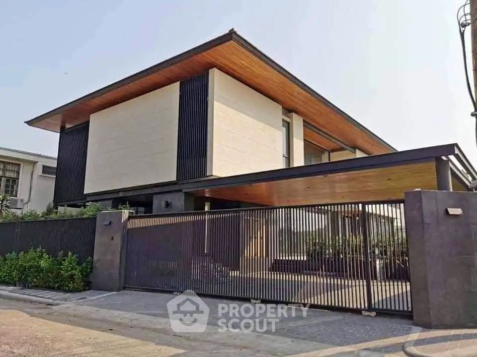 Modern luxury house with sleek design and spacious exterior, featuring a stylish gated entrance and wooden accents.