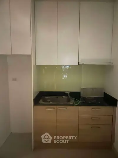 Compact kitchen with modern cabinetry and built-in gas stove, ideal for efficient cooking in small spaces.