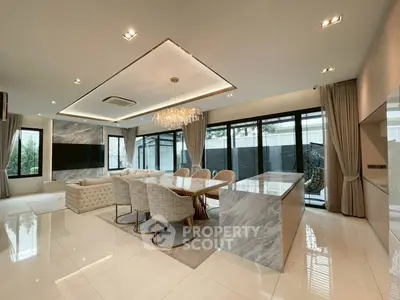 Luxurious open-plan living and dining area with elegant marble finishes and modern chandelier.