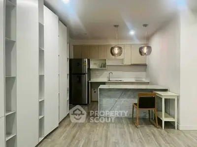 Modern kitchen with sleek design and open layout, featuring stylish pendant lights and contemporary furniture.