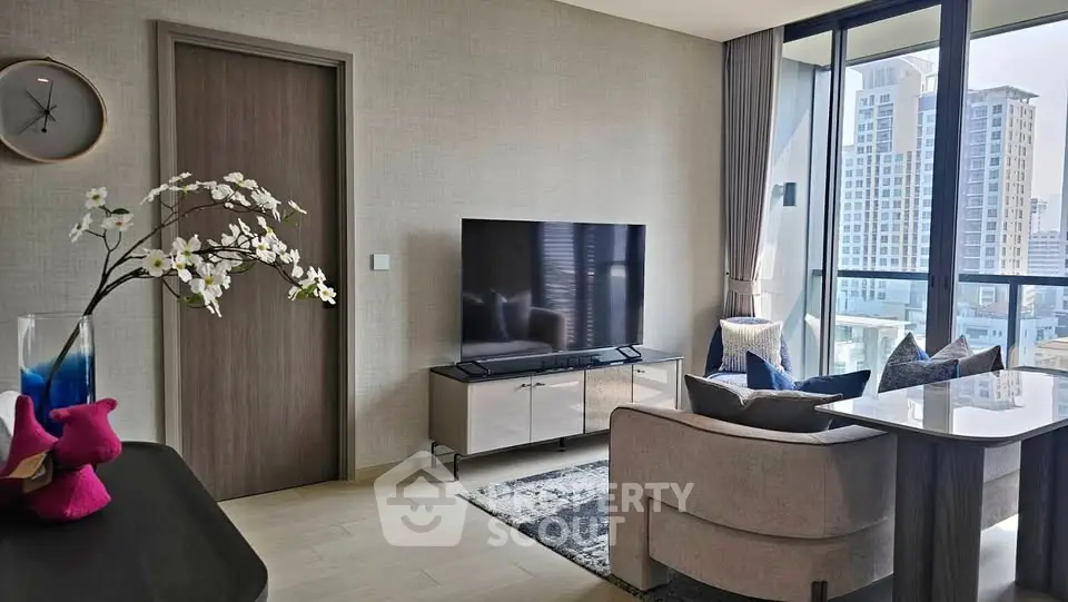 Modern living room with large TV, stylish decor, and city view from floor-to-ceiling windows.