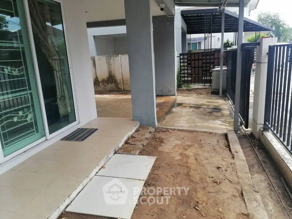 Spacious outdoor area with tiled entrance and modern fencing