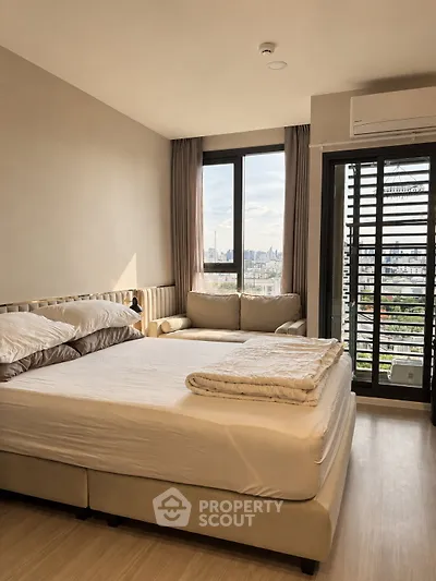 Modern bedroom with city view, featuring a cozy bed and stylish decor in a high-rise apartment.