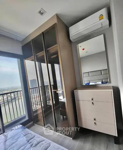 Modern bedroom with mirrored wardrobe and river view balcony.