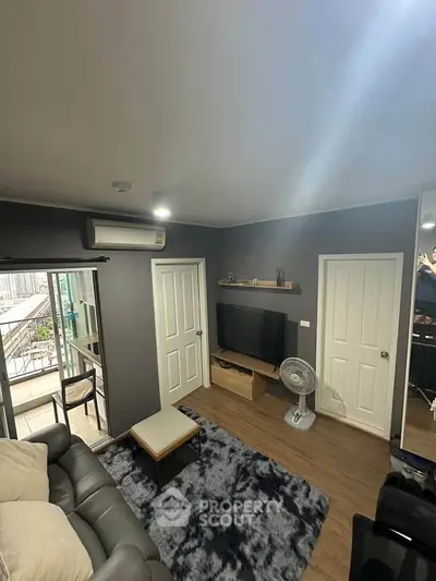 Modern living room with balcony access, featuring sleek furniture and stylish decor.