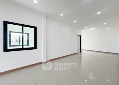 Spacious modern interior with sleek tile flooring and ample natural light, perfect for versatile living arrangements.