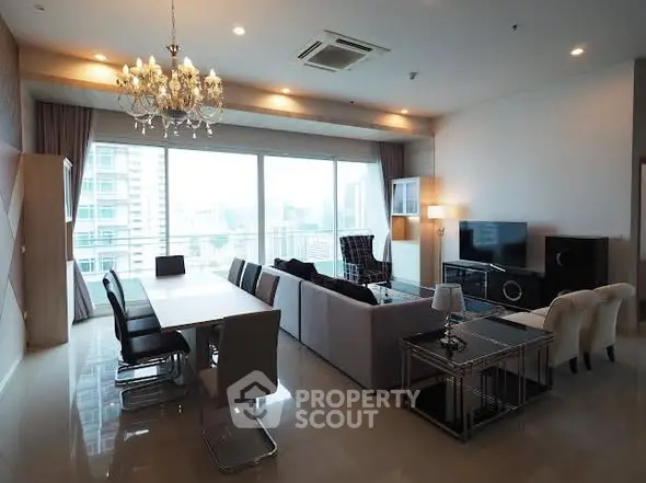 Luxurious modern living room with city view, elegant chandelier, and spacious seating area.