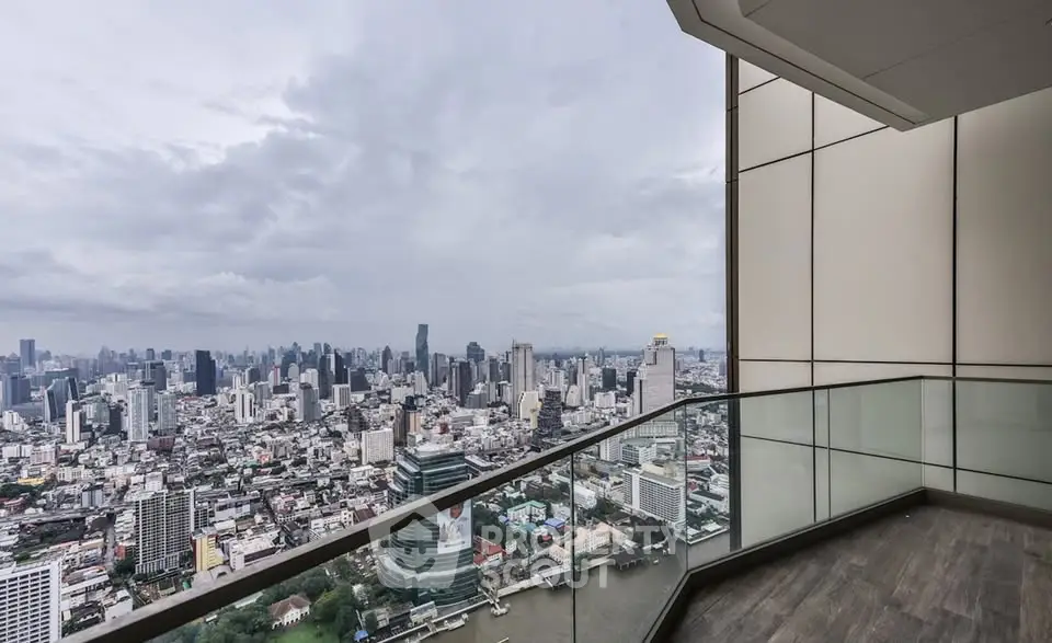 Stunning cityscape view from a modern high-rise balcony with glass railing.