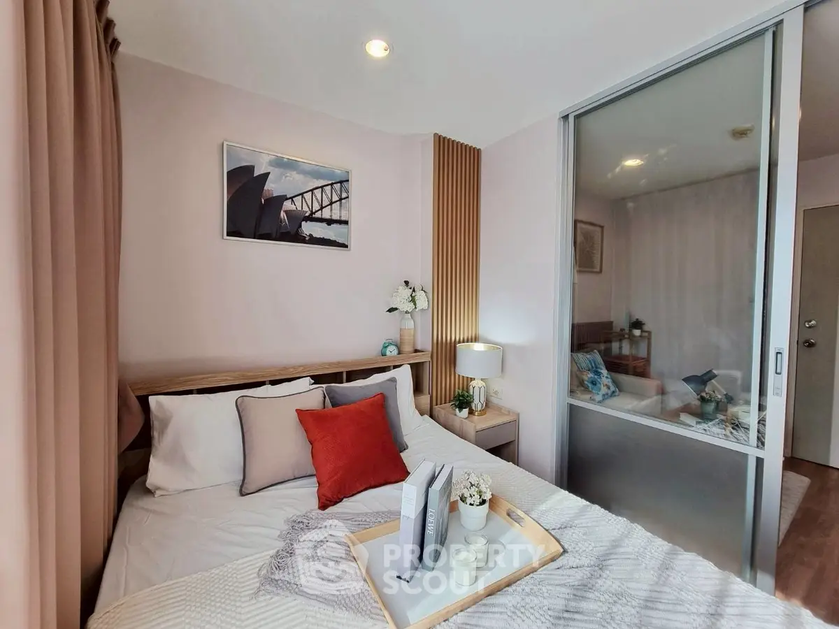 Cozy bedroom with modern decor and sliding glass partition, featuring stylish bedding and ambient lighting.