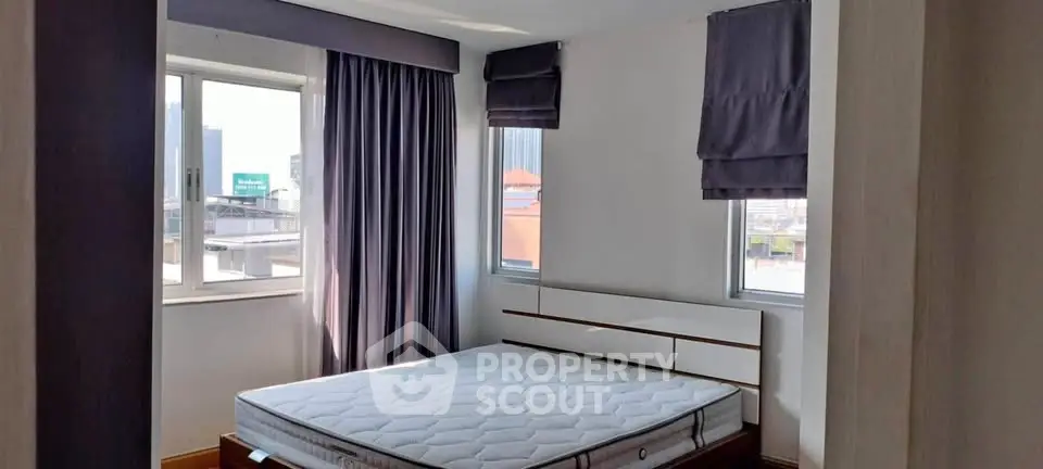 Bright bedroom with large windows and modern decor in urban apartment