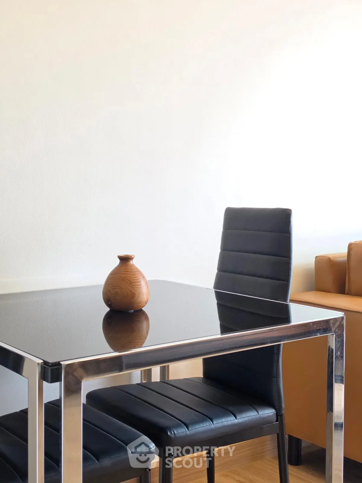 Modern dining area with sleek black table and leather chairs, perfect for contemporary living spaces.