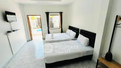 Spacious bedroom with two beds and pool view, ideal for relaxation and comfort.