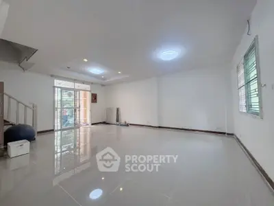 Spacious living room with modern lighting and large windows for natural light.