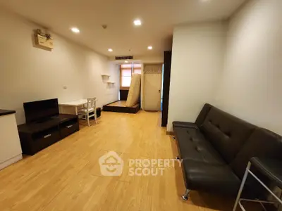 Spacious living room with modern furniture and wooden flooring in a cozy apartment.
