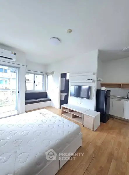 Bright studio apartment with modern furnishings and open layout in urban setting.