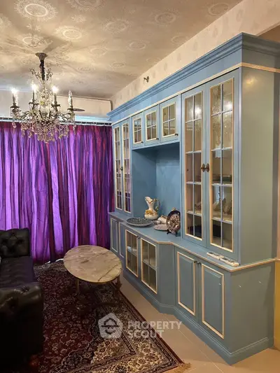 Elegant living room with vintage chandelier and blue cabinetry