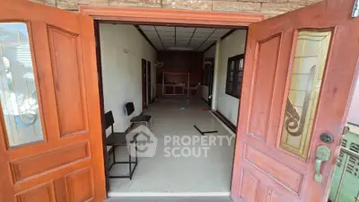 Spacious entryway with wooden doors leading to a versatile interior space, ideal for customization.