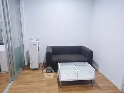 Cozy small living room with modern sofa and glass coffee table, perfect for minimalist living.