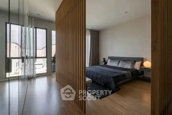 Modern bedroom with wooden partition and large windows in stylish apartment