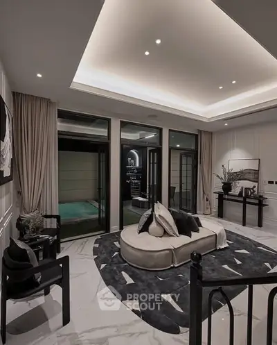 Luxurious living room with modern decor and pool view, featuring elegant lighting and stylish furniture.