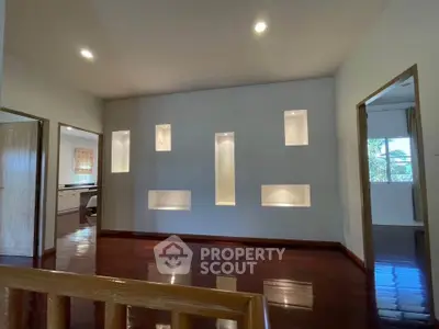 Spacious living room with modern recessed lighting and polished wooden floors