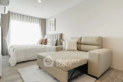 Modern bedroom with stylish decor and natural light, featuring a cozy bed and comfortable seating area.