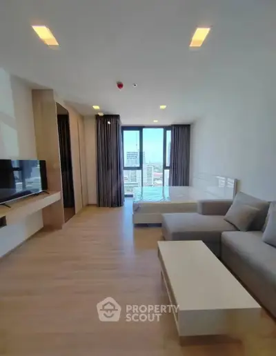 Modern studio apartment with city view, featuring sleek furniture and large windows for natural light.