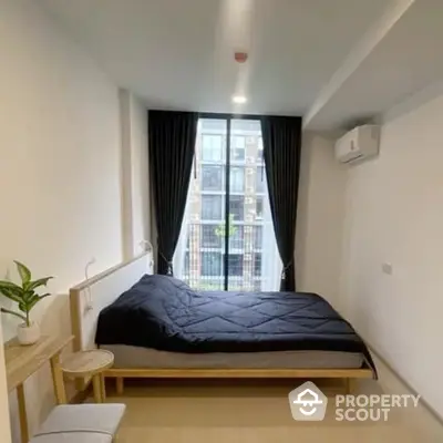 Modern minimalist bedroom with large window, natural light, and sleek wooden furniture, perfect for urban living.