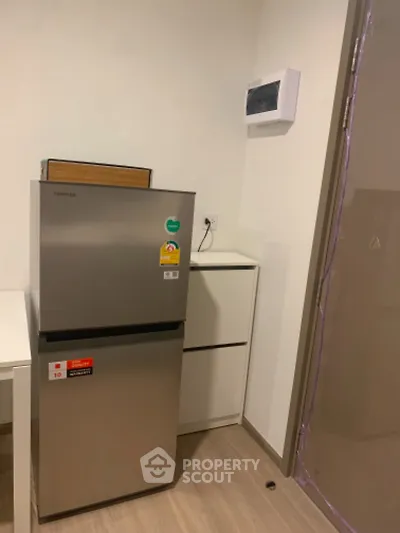 Modern kitchen corner with compact fridge and sleek cabinetry
