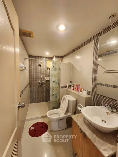 Modern bathroom with shower, toilet, and stylish sink in a cozy setting.