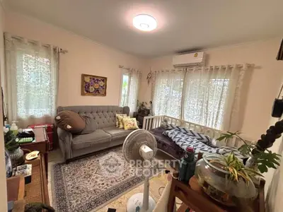 Cozy living room with elegant sofa, air conditioning, and decorative rug, perfect for relaxation.