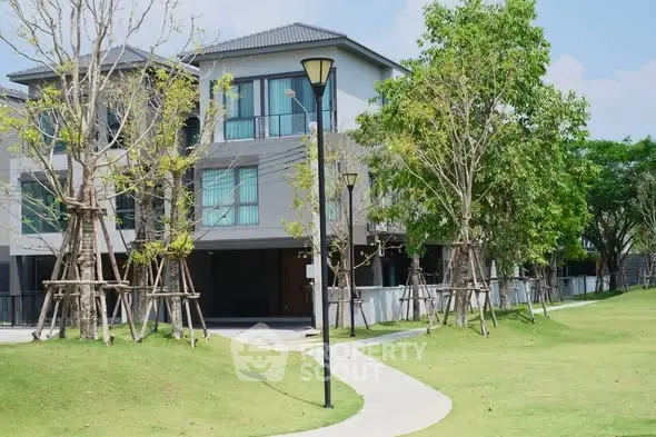 Modern residential building with lush green surroundings and well-maintained landscape.