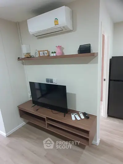 Modern living room with TV, air conditioner, and stylish shelving.