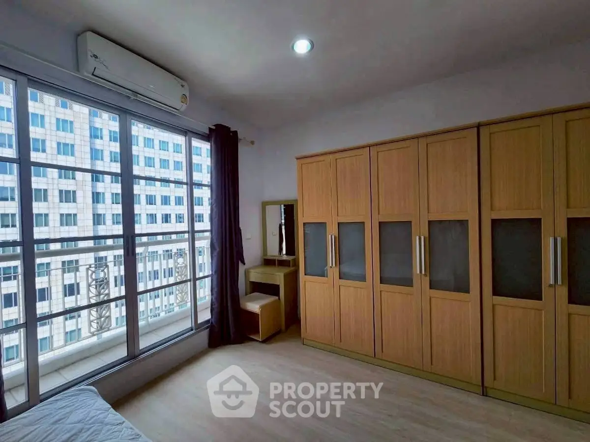 Spacious bedroom with large wardrobe and city view window