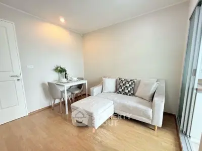 Cozy living room with modern sofa and dining area, perfect for small apartments.