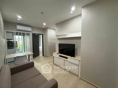 Modern living room with sleek design and natural light, featuring a cozy sofa and wall-mounted TV.