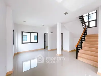 Spacious modern living room with sleek staircase and large windows