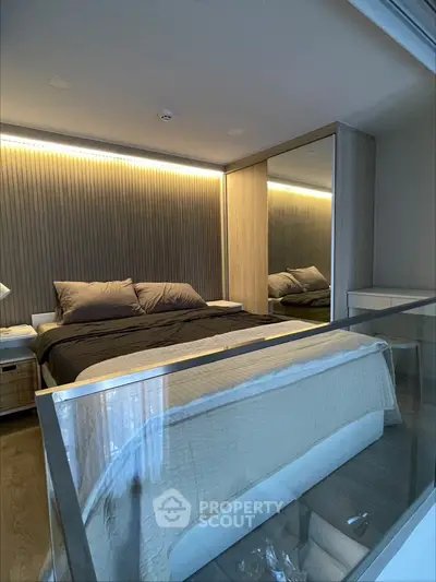 Modern bedroom with sleek design and mirrored wardrobe