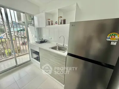 Modern kitchen with stainless steel fridge and open layout in a bright apartment.