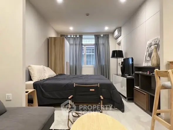 Modern bedroom with stylish decor and natural light, featuring a cozy bed and contemporary furniture.