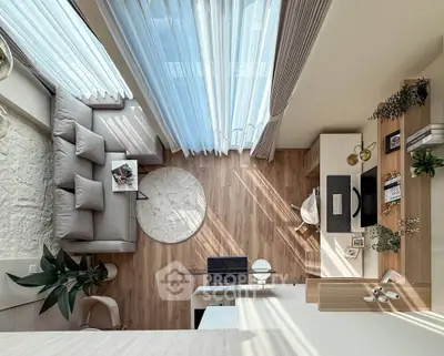 Modern living room with stylish decor and natural light, featuring a cozy sofa and elegant wooden flooring.