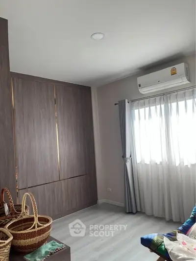 Bright bedroom with modern air conditioning and elegant wooden wardrobe