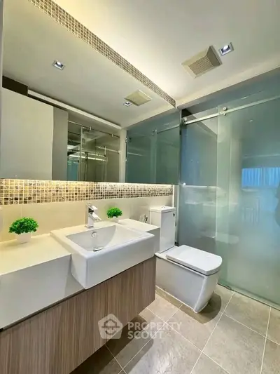 Modern bathroom with sleek fixtures and glass shower enclosure