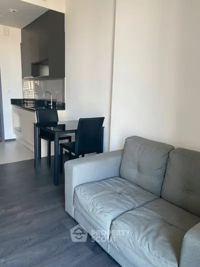 Modern apartment interior with sleek kitchen and cozy living area, featuring contemporary furniture and stylish design.