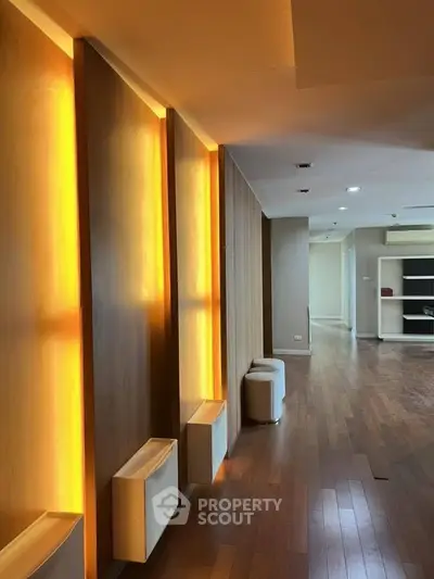 Spacious modern interior with warm lighting and wooden flooring, ideal for stylish living.