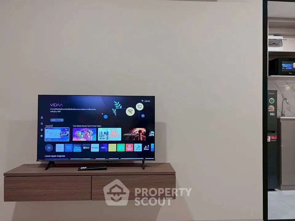 Modern living room with wall-mounted TV and sleek wooden console.