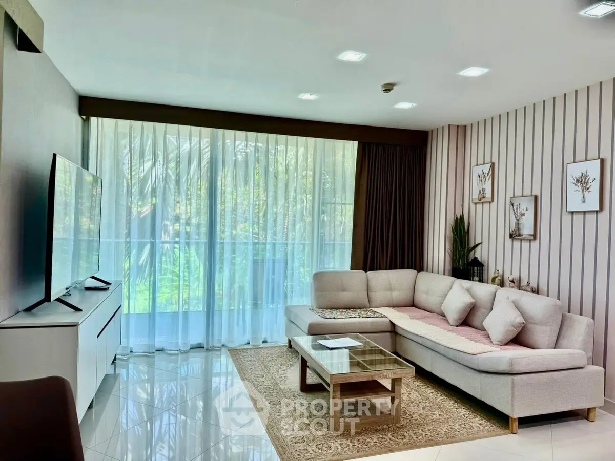 Elegant living room with modern decor and large windows offering garden views.